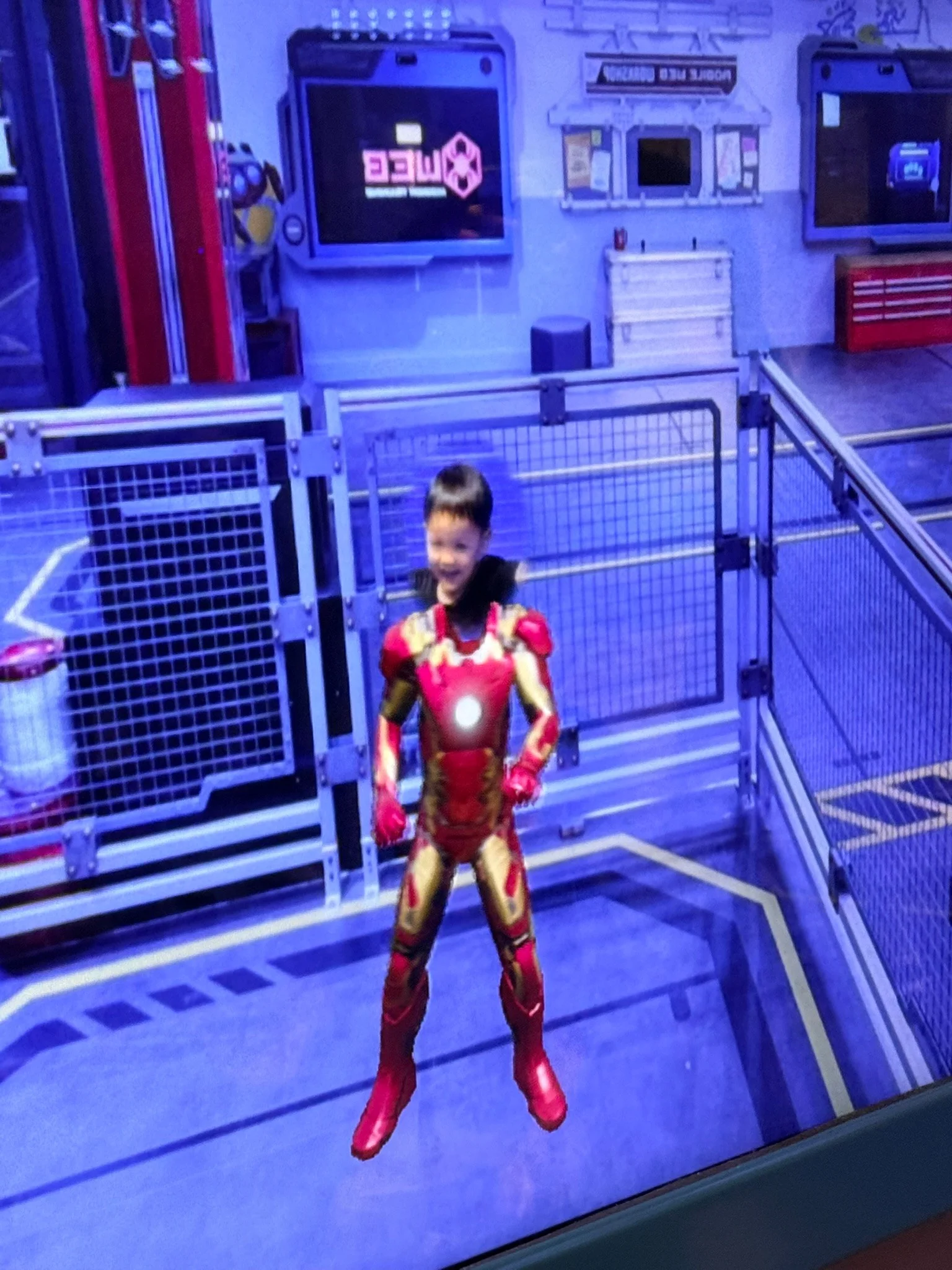 Ethan appearing as Iron Man on screen in the superhero training game.
