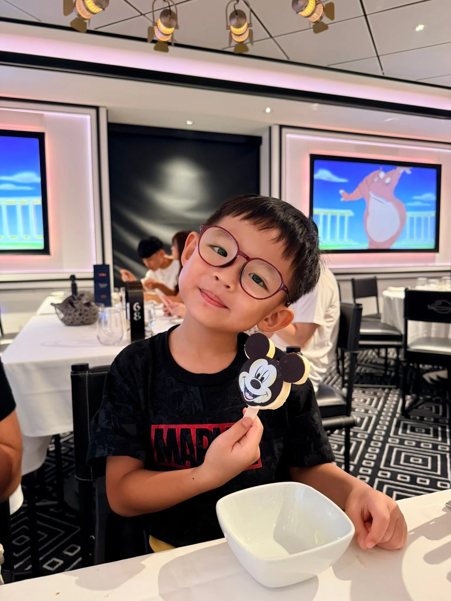 Lucas smiling with a Mickey ice cream bar at Animator’s Palate.