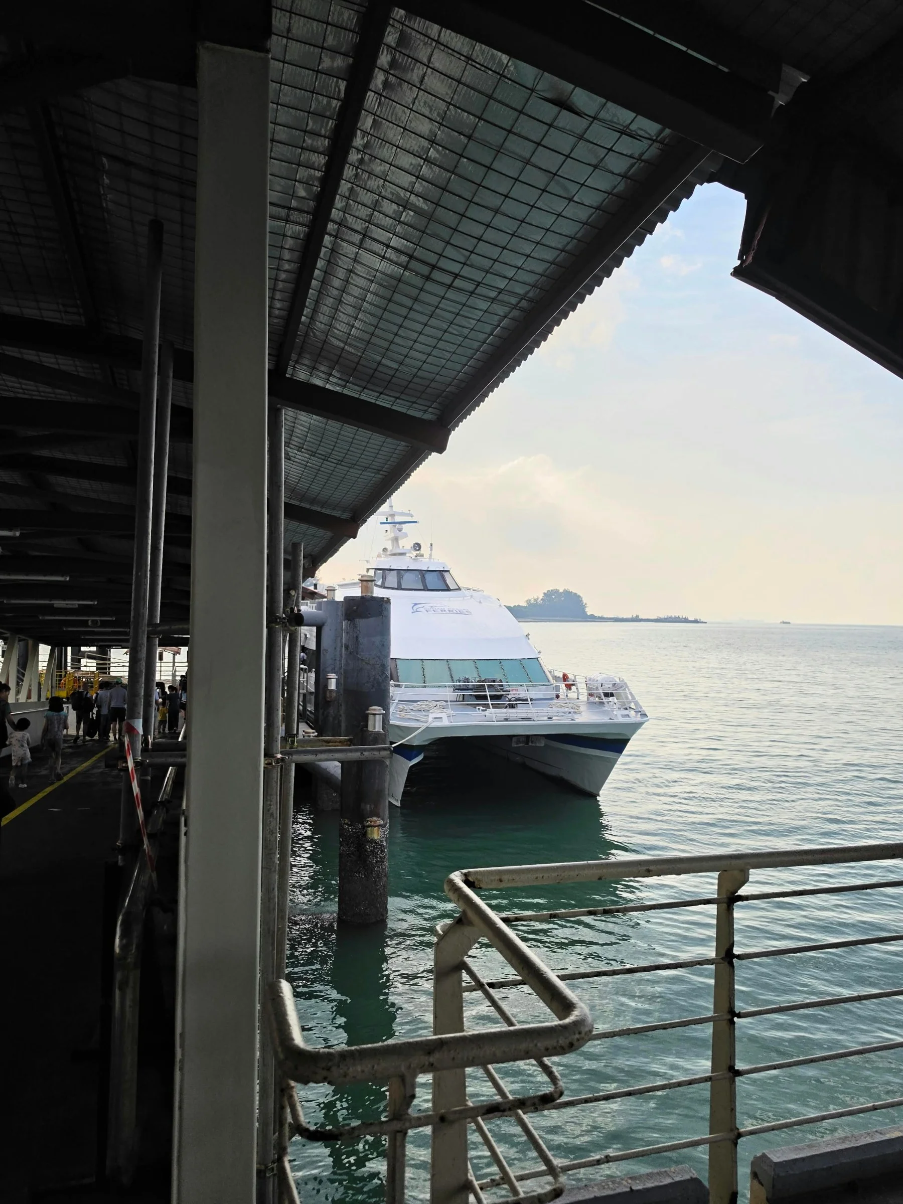 A passenger ferry docked beside the terminal, viewed from the boarding area.